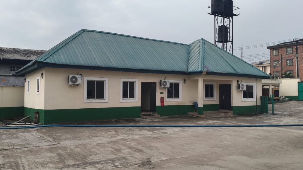Single-storey site office with a green roof, beside a water tower