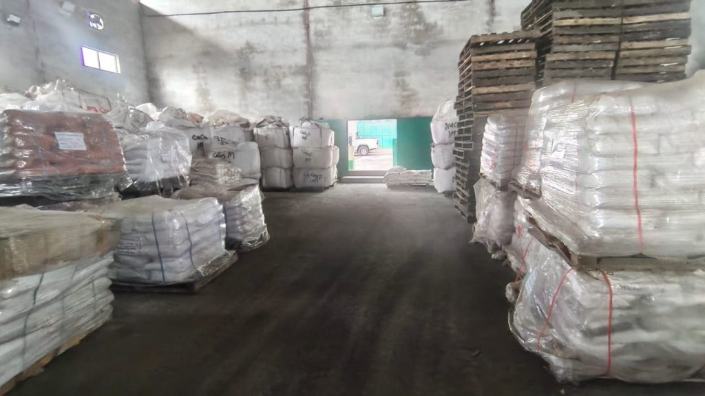 Warehouse aisle lined with pallets of chemical sacks